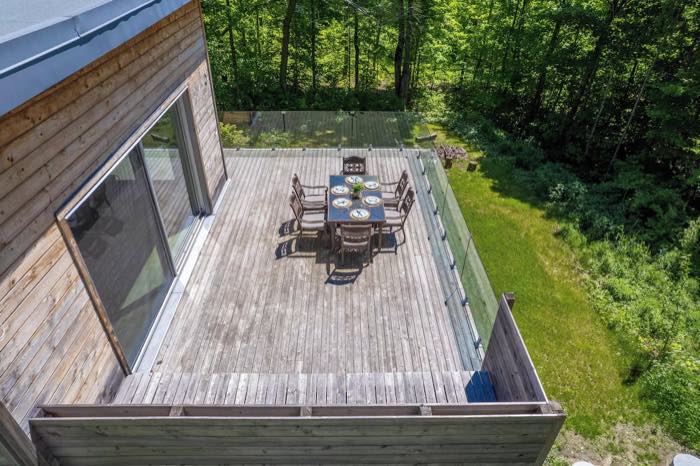 La terrasse en bois vue d'en haut, avec sa table et la forêt autour